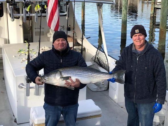 Captain Scottie and a customer smile and pose with fish